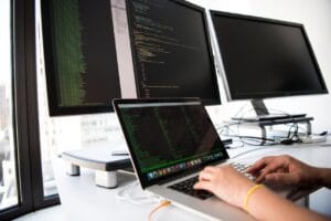 A developer's desk setup with multiple monitors displaying code and technical diagrams, illustrating a focused work session on programming.
