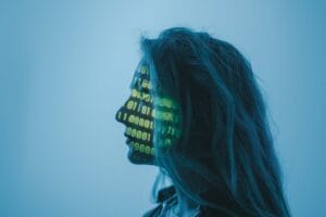 Profile of woman with binary code projected on face glow